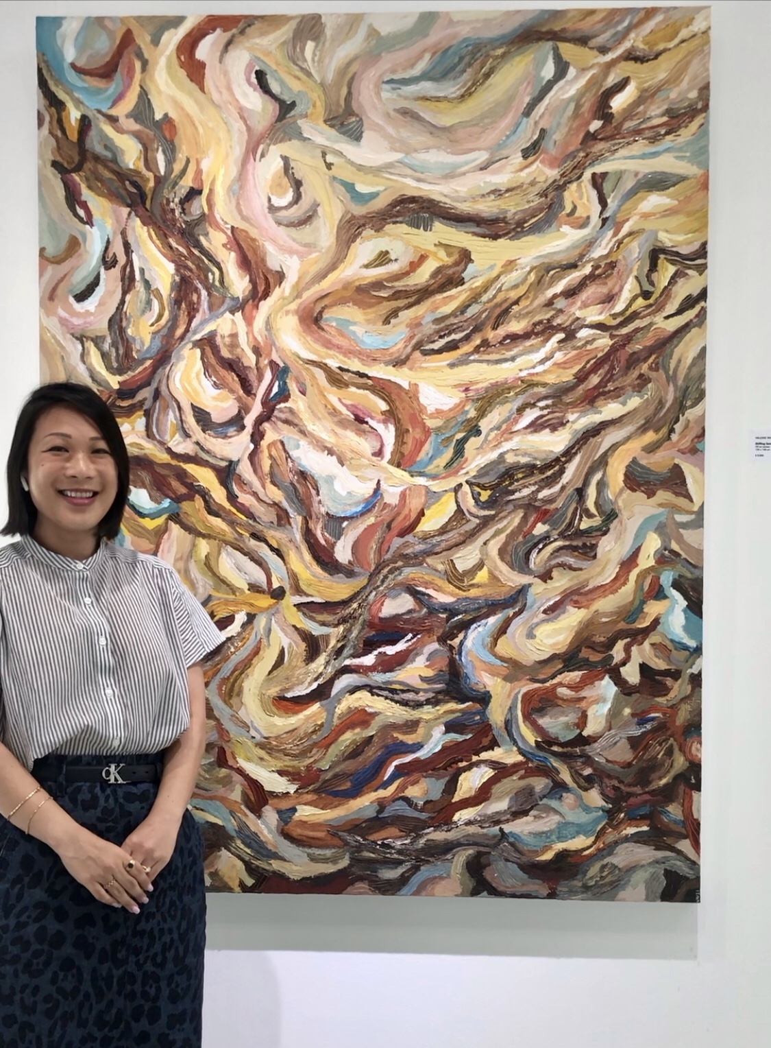 Vanessa next to a painting by Valerie Ng.