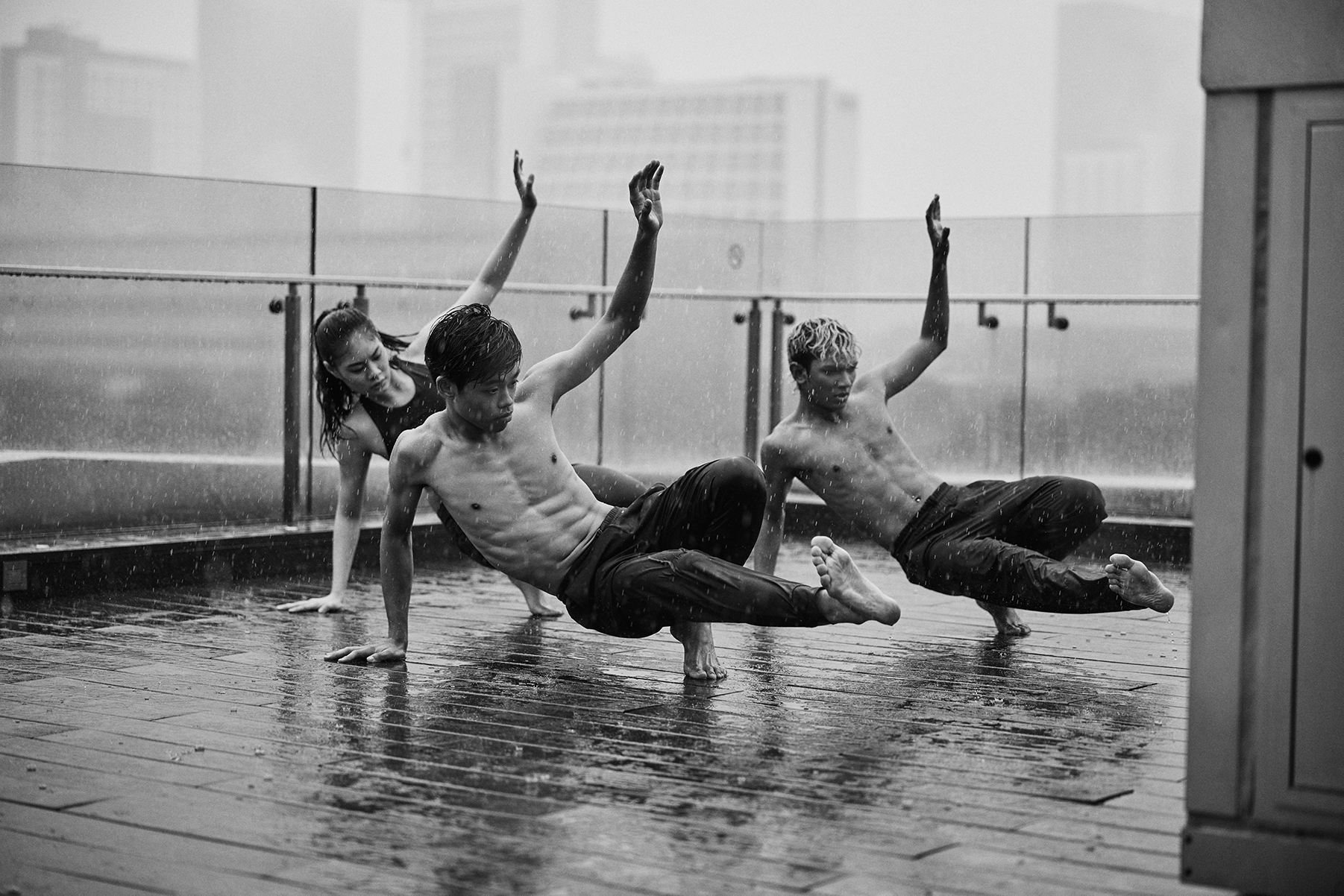 Students dance in a seasonal downpour on the outdoor roof garden of the National Gallery Singapore