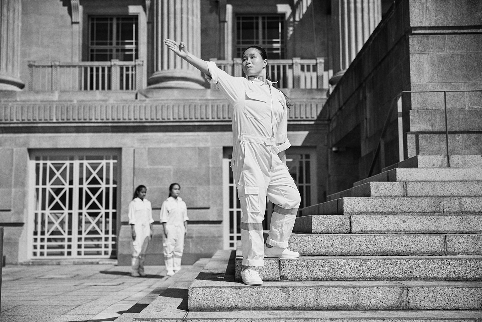 Dancer stands on the steps of the historic old Supreme Court of Singapore
