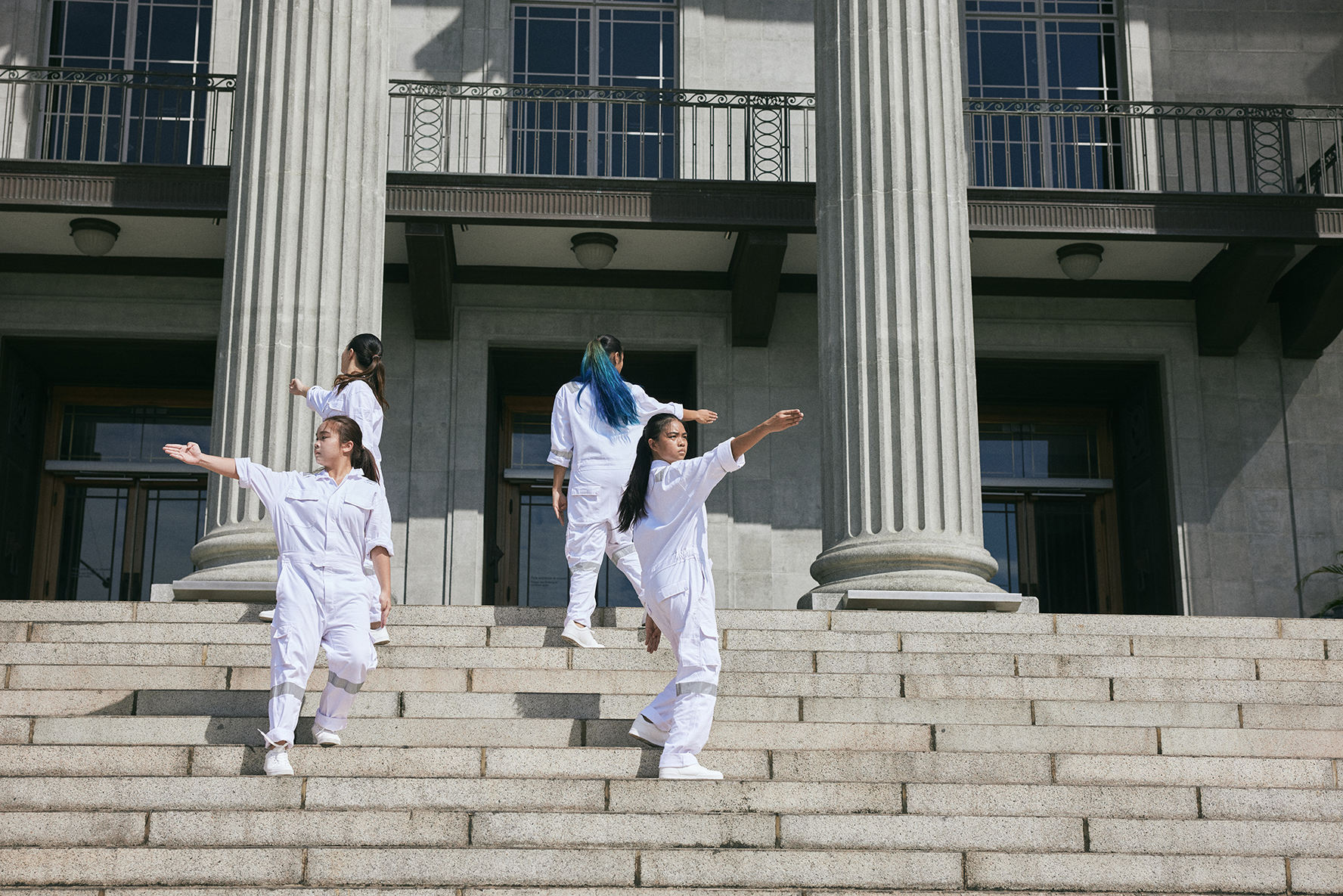 Students perform in the blazing sun on the outdoor steps of the historic City Hall building.