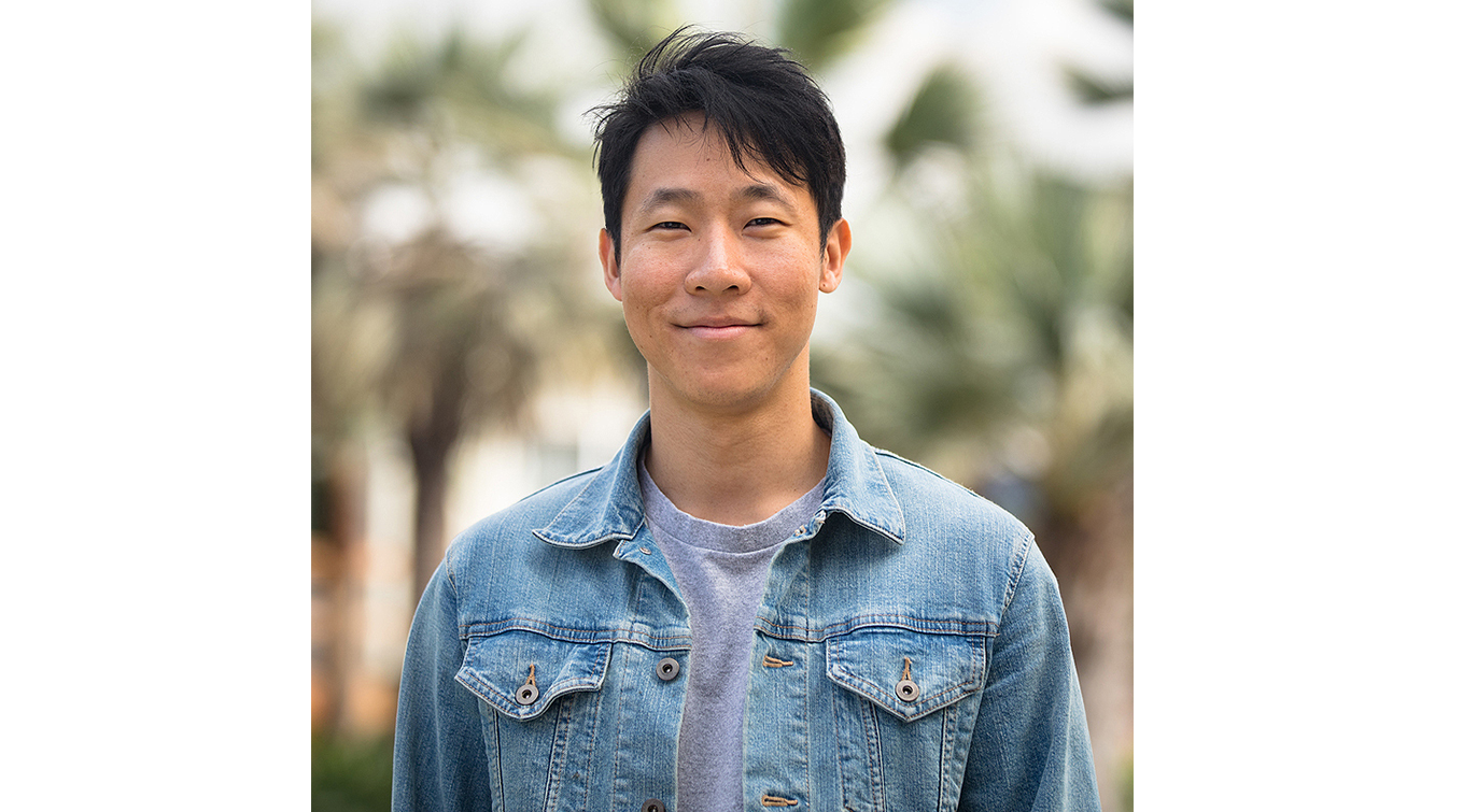 Marcus Yuen profile picture. He wears a denim jacket in front of out of focus palm trees.