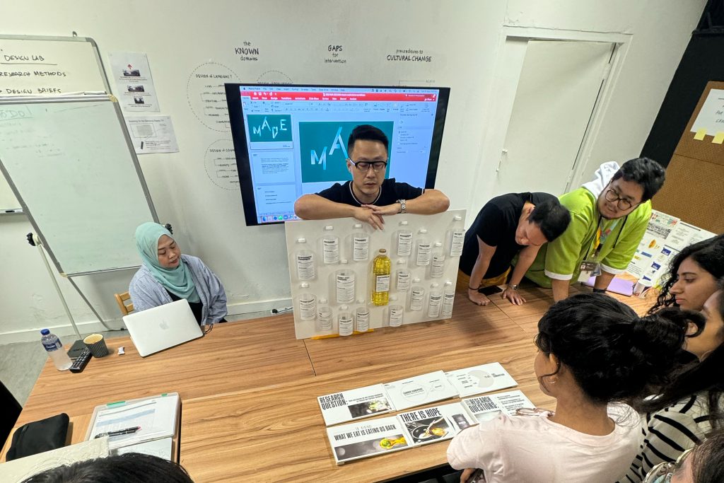 Sheng Jin (second from left) shares his research with classmates during a formative presentation as Nur Hidayah, Dean Faculty of Design (first from left) supervises.