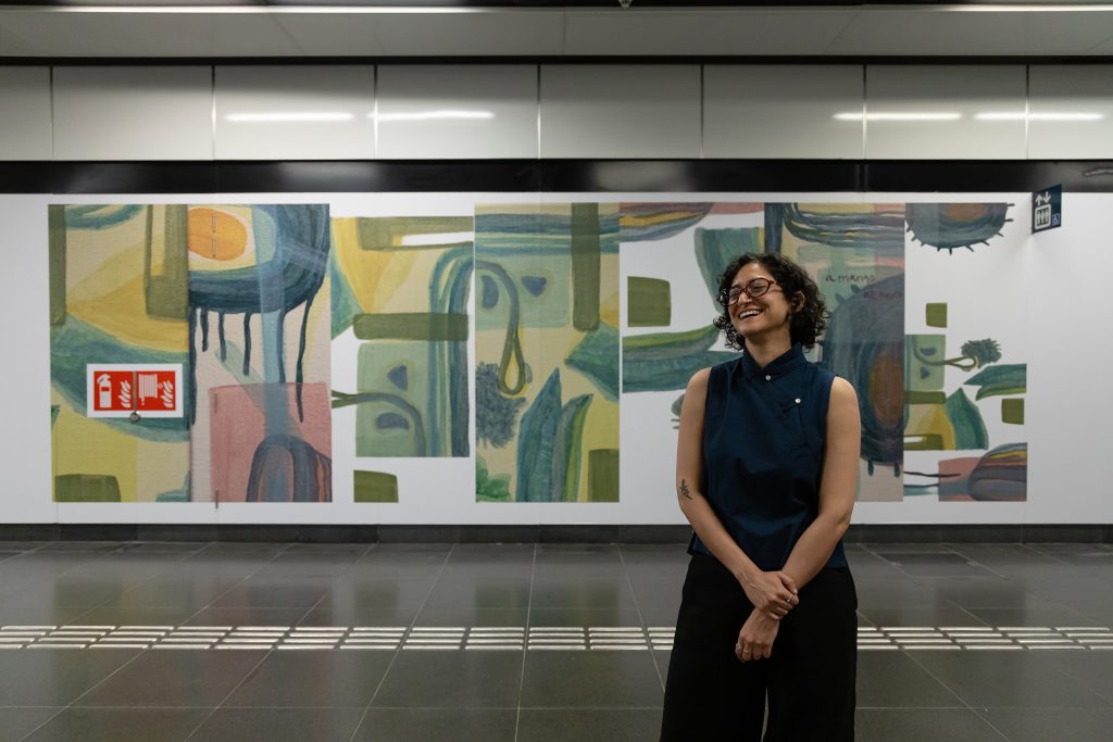 MA Fine Arts graduate Nanaki Singh stands before her work.