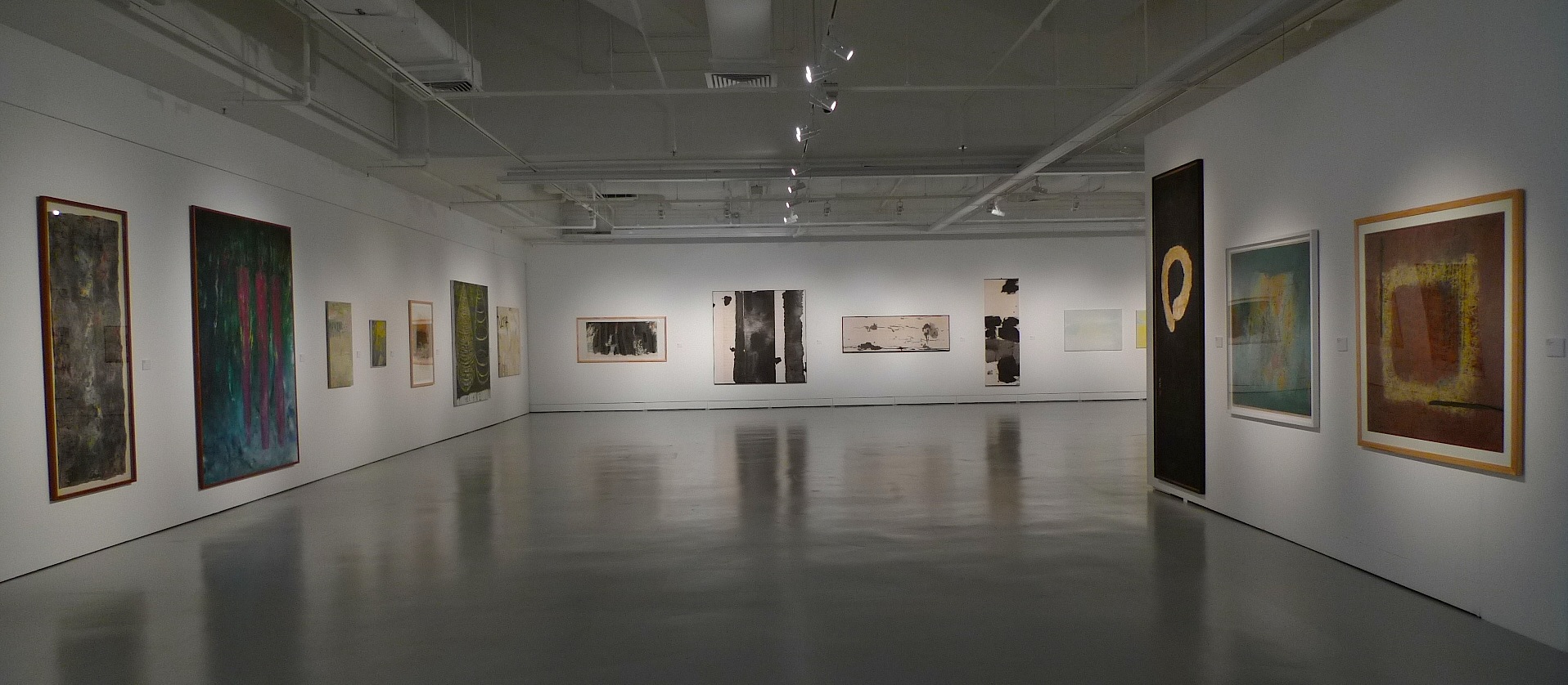 LASALLE gallery with abstract paintings in varied sizes and colours displayed along white walls under spotlights.