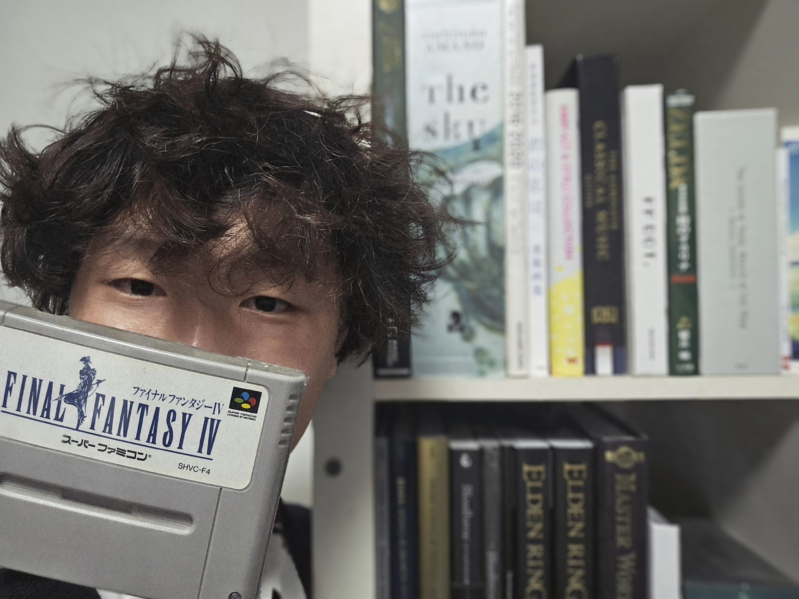 Ngiam with his treasured 1991 edition of Final Fantasy IV, in front of a bookshelf of other fantasy references which have informed his work.
