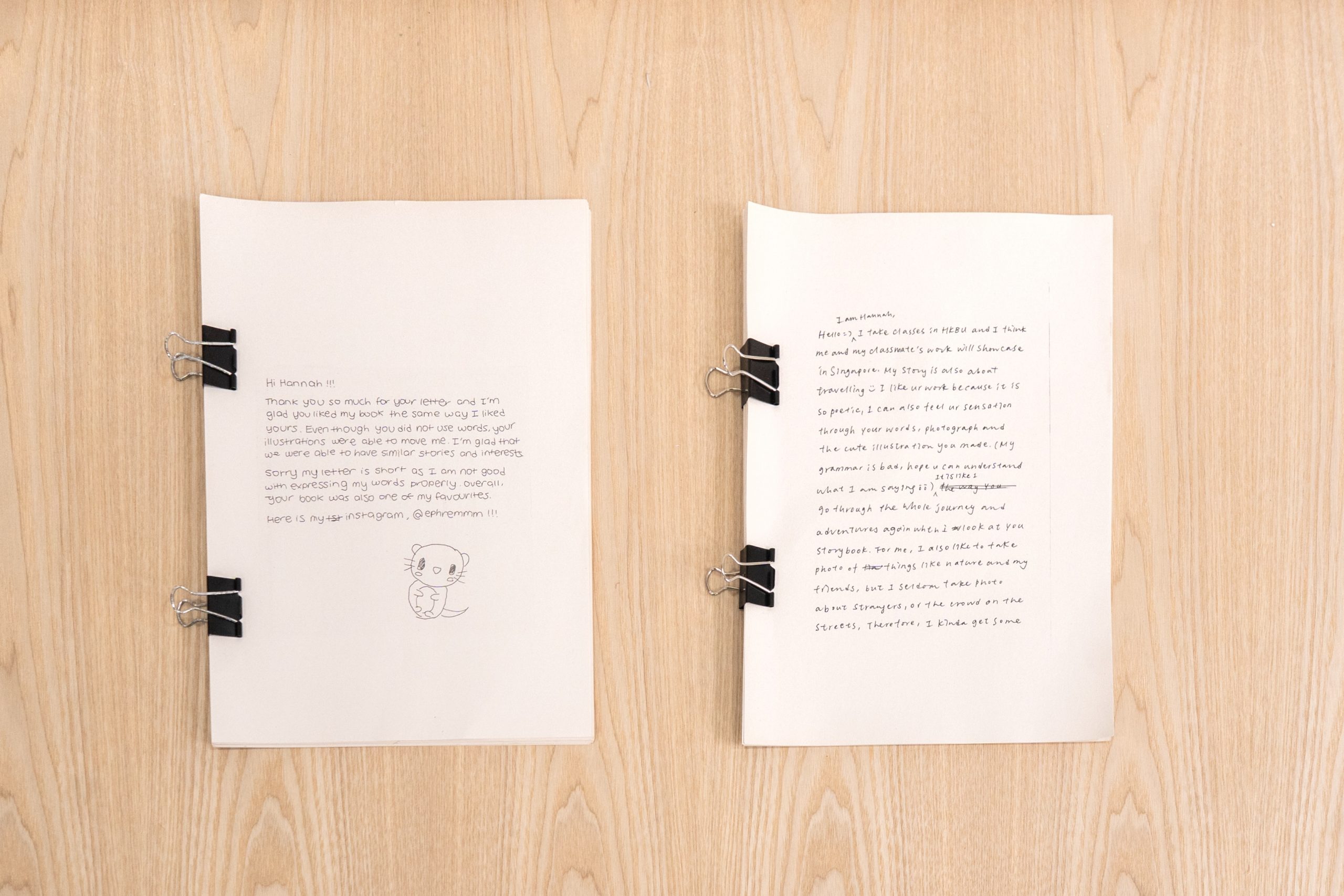 Two excerpts of letters written from participants to each other are laid flat on a wooden surface for visitors to view.