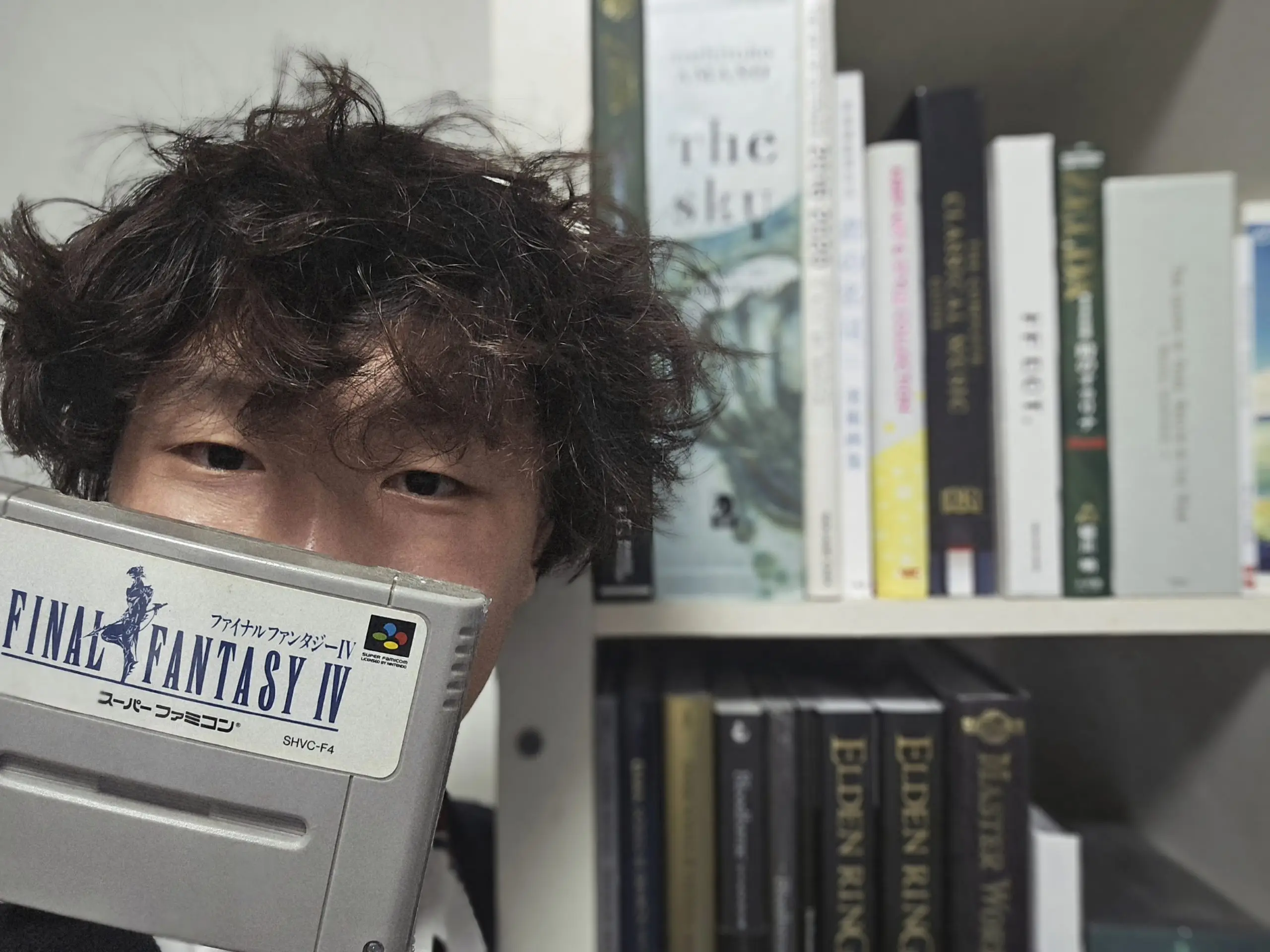 Ngiam with his treasured 1991 edition of Final Fantasy IV, in front of a bookshelf of other fantasy references which have informed his work.
